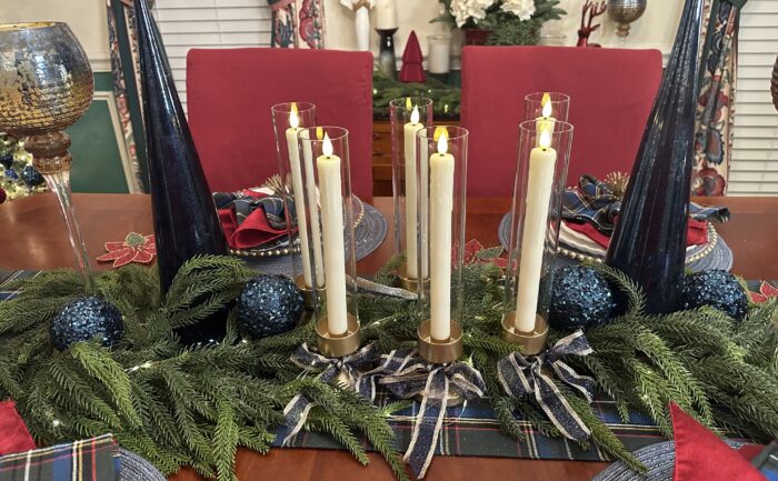 Christmas dining table and tree décor with deep blue and gold tablescape Deep blue and gold decorated with flameless candles, garland, and plaid table runner