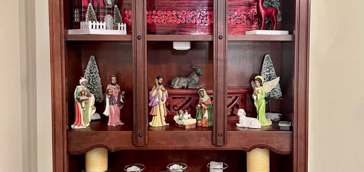 Manger scene display in hutch illuminated by rechargeable puck lights for Christmas