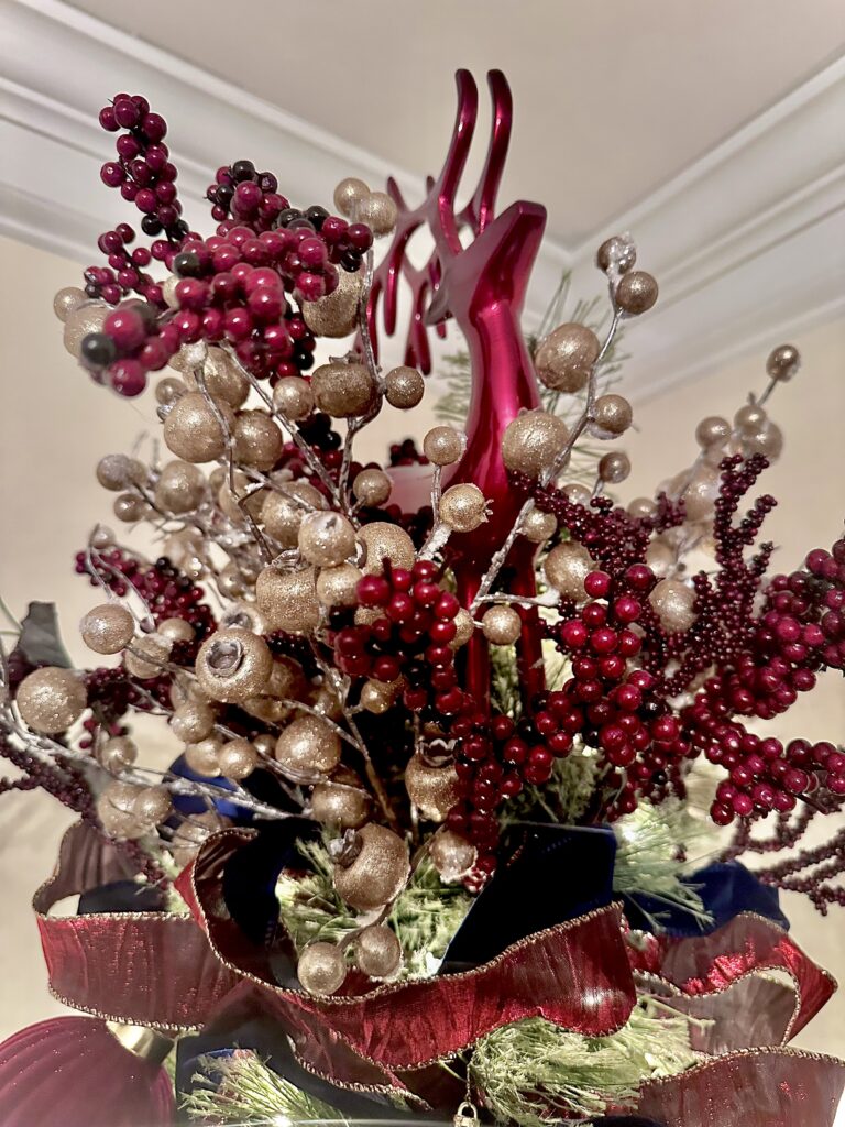 Deep red and gold berry Christmas tree topper with a red reindeer accent